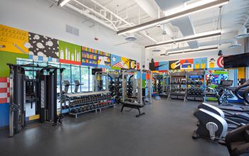 a gym with weights and cardio machines and colorful wall art at Inspire West Town, CHICAGO, IL, 60642